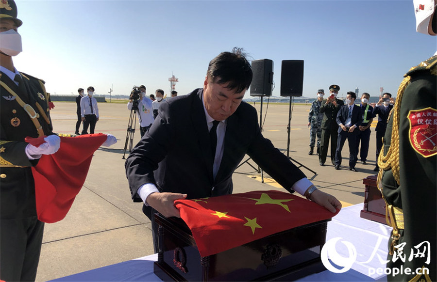 中國駐韓國大使邢海明為志願軍烈士棺槨覆蓋國旗。 張悅 攝