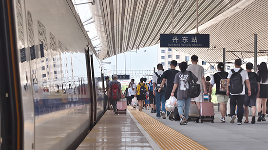 图为7月21日，旅客从丹东站踏上旅程。中国铁路沈阳局供图