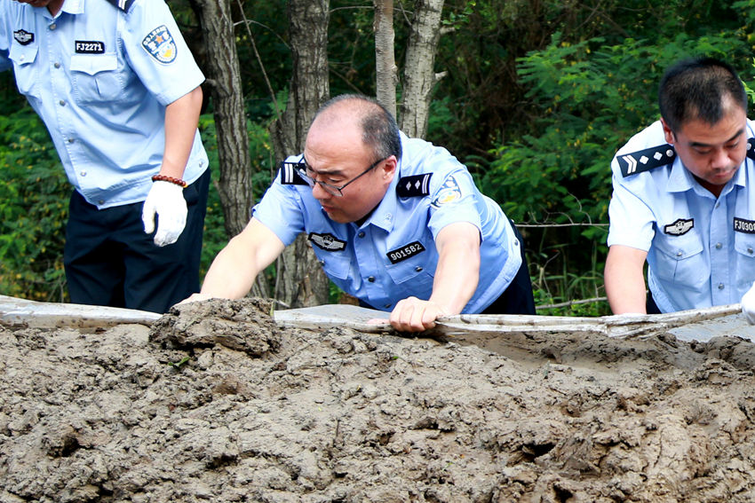 盤錦汛情發生以來，老民警紛紛請纓投入到抗洪搶險第一線，又悶又熱的天氣，他們不知疲倦的身影，一直在最艱苦的地方堅守。（遼寧省公安廳供圖）