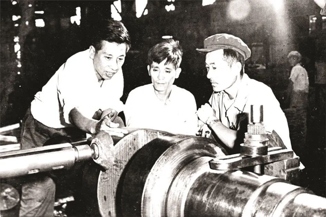 王崇伦（左）与工友一同开展技术攻关。鞍钢集团供图