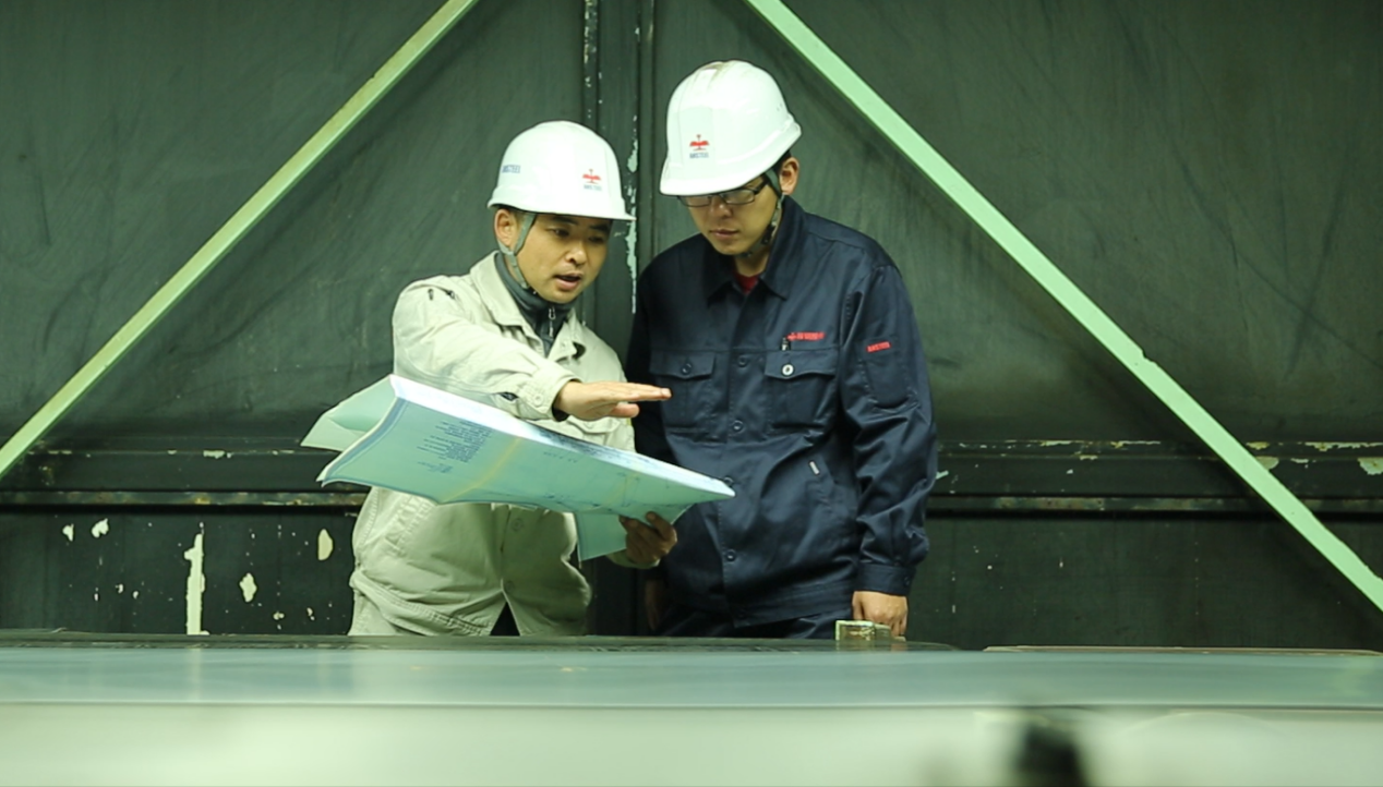 李超（左）在车间与同事交流工作。    鞍山钢铁党委宣传部供图