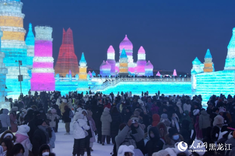 入夜后，流光溢彩的哈尔滨冰雪大世界吸引众多游客前来打卡拍照。人民网记者 徐成龙摄
