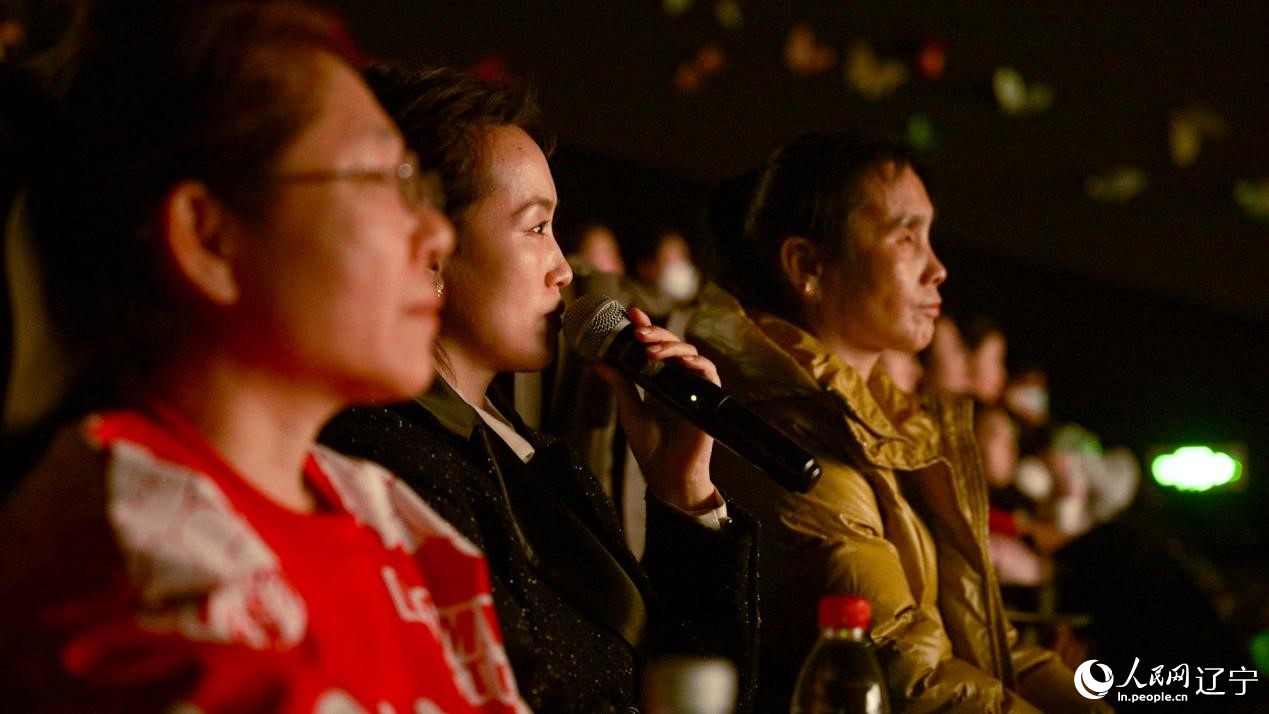 秋红在为电影解说，吴莲香坐在秋红旁边。人民网记者 邱宇哲摄