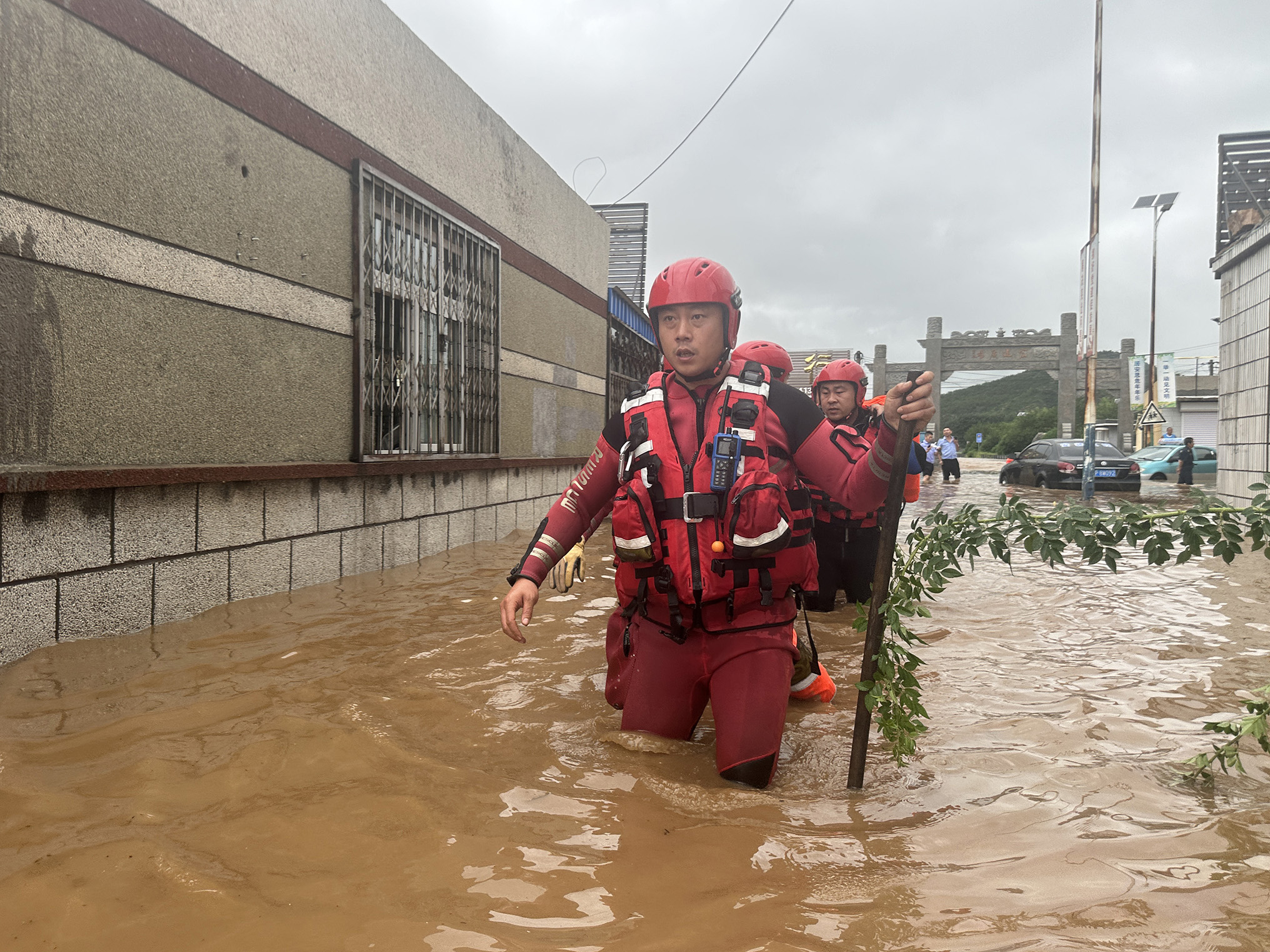 8月20日，辽宁省葫芦岛市连山区，水下情况不明，消防员蹚水探路前进。辽宁省消防救援总队供图