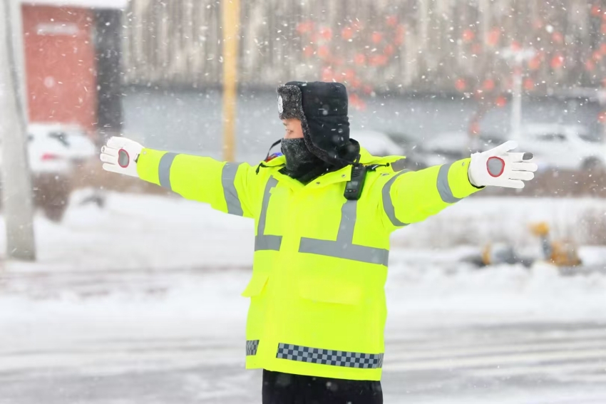 风雪中，公安交警在街头指挥交通。人民网记者 王斯文摄