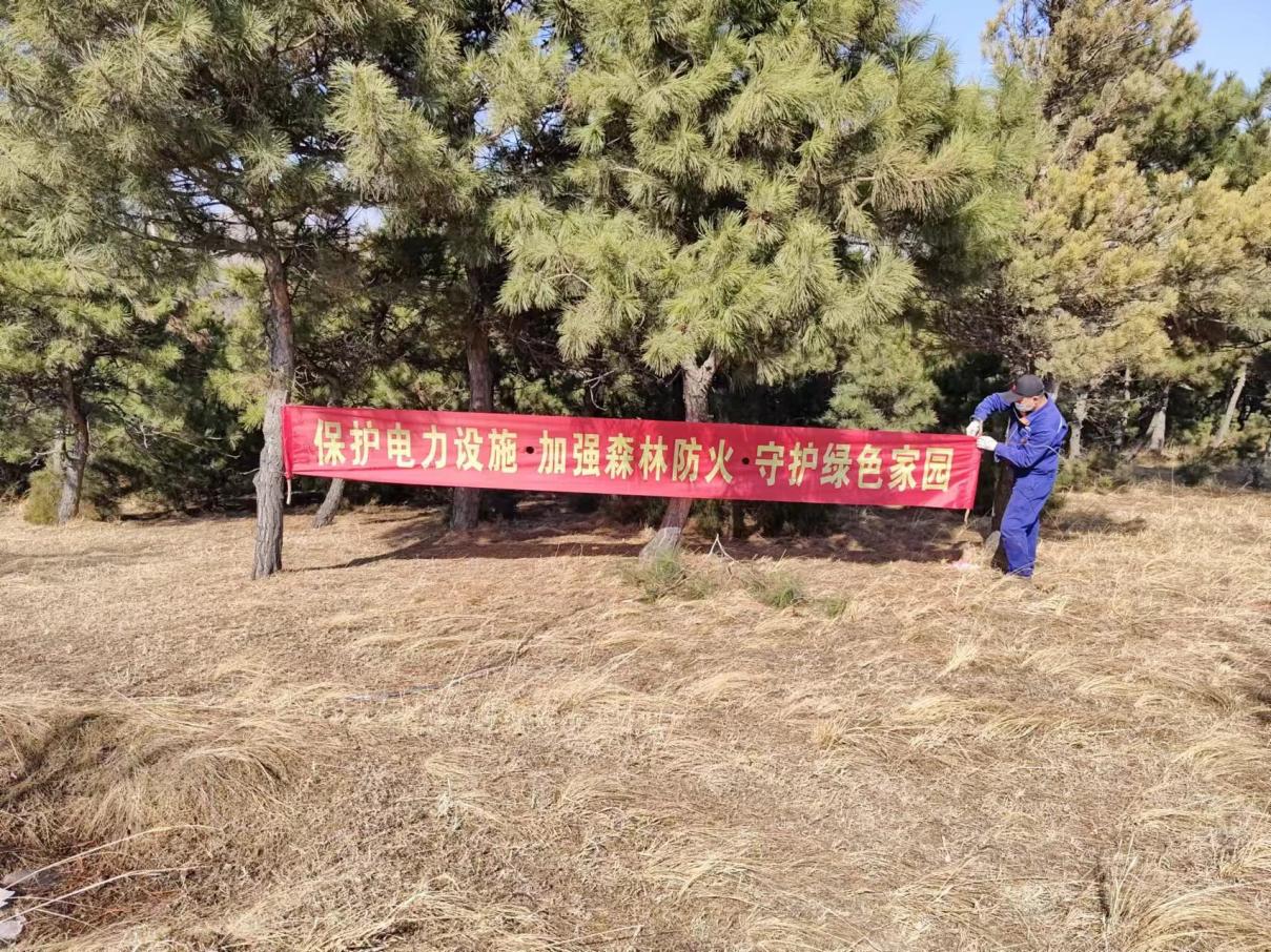 铁岭公司输电运维人员王志民在220千伏调法1号线7号悬挂防山火条幅。