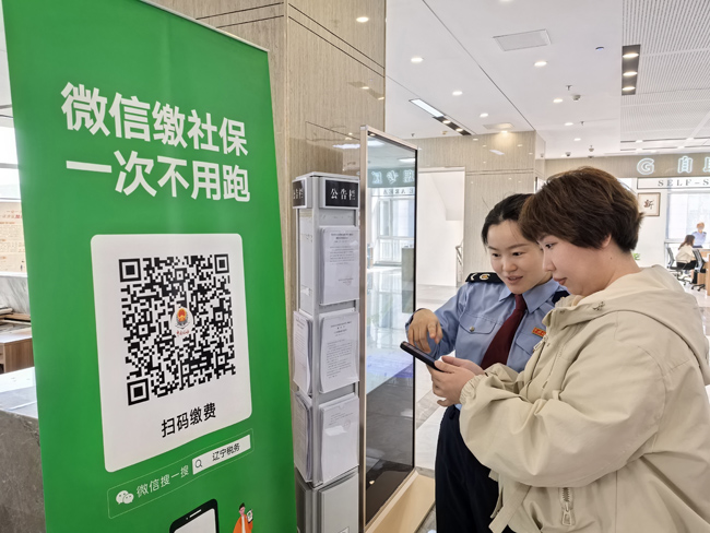 针对部分纳税人缴费人不熟悉线上社保缴费流程的情况，在办税服务大厅内，沈抚示范区税务局税务干部手把手指导纳税人缴费人通过微信进行社保缴纳。刘子龙摄