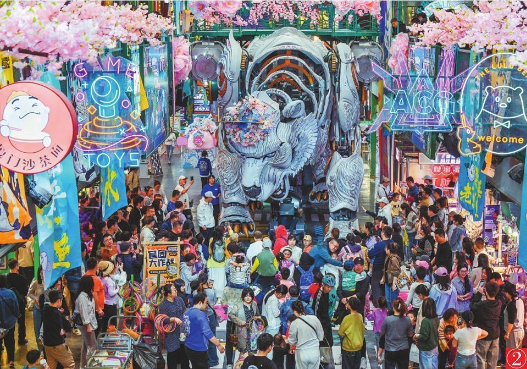 假期的大连熊洞街，游客聚集在机甲巨熊周围欣赏互动表演。 本报记者 查金辉 摄