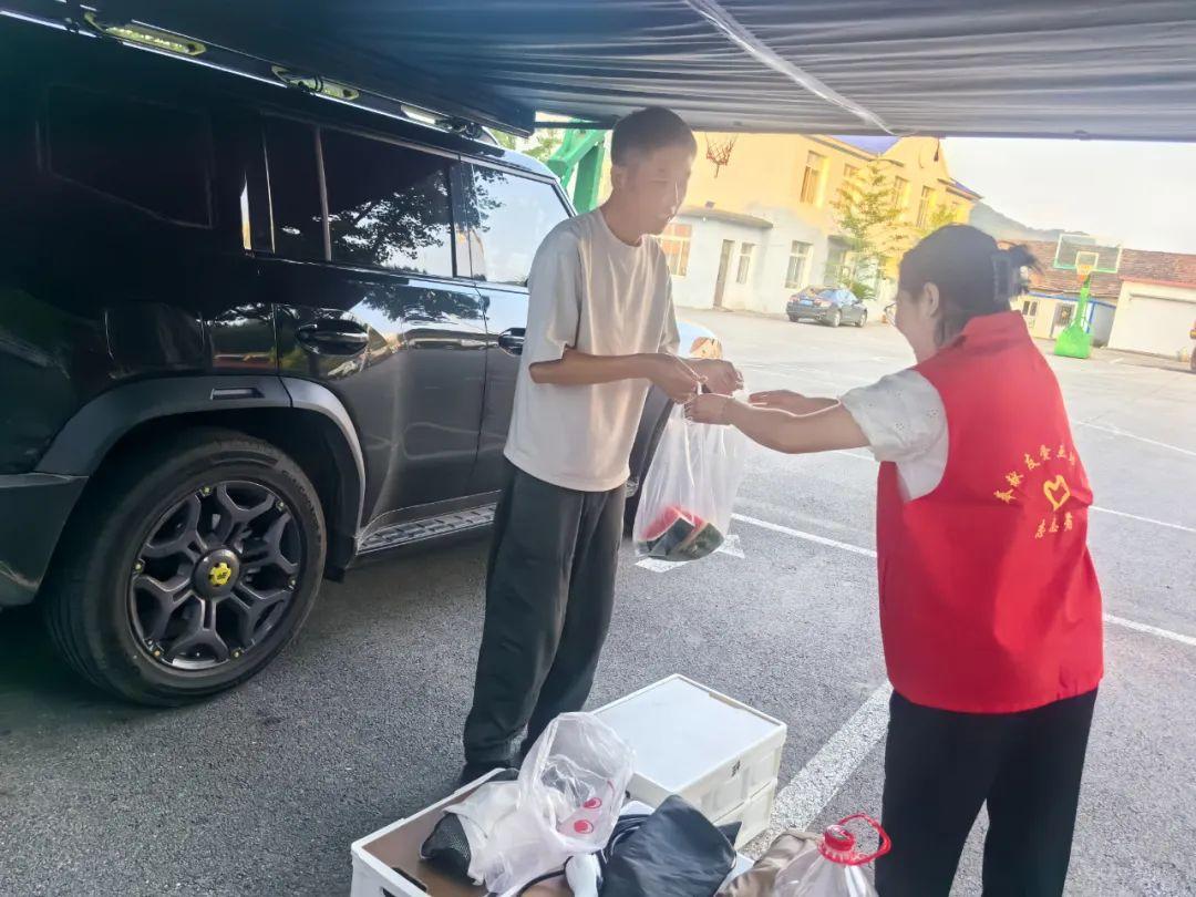 志愿者给游客分享西瓜解暑。丹东市委网信办供图