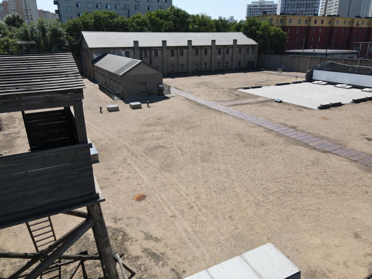 二战盟军战俘营遗址内，按照历史资料修复的瞭望塔和远处的营房旧址。人民网记者 邱宇哲摄