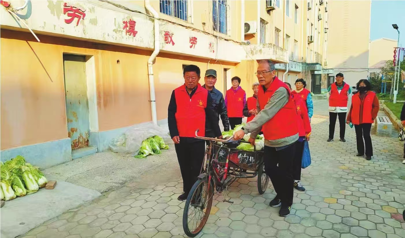 营口华安社区老年互帮互助队从菜市场买来秋菜往刘德贤家送。 记者 佟利德 摄