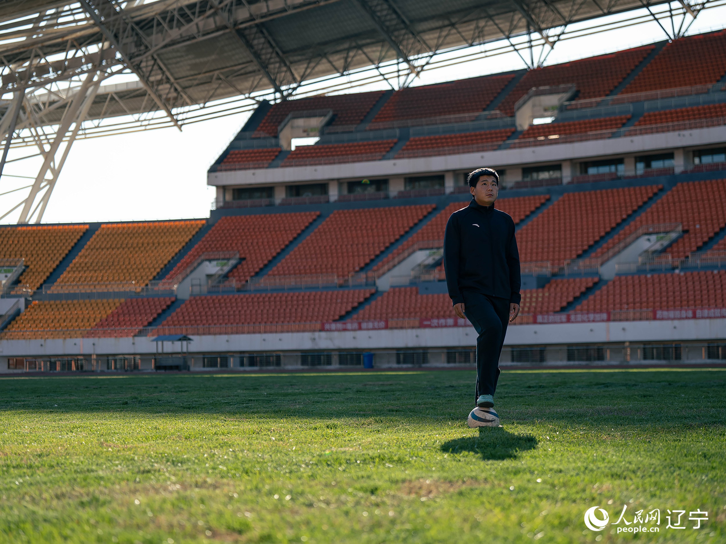 王立维站在足球场上。人民网记者 邱宇哲摄