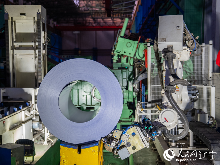 鞍钢股份冷轧厂彩涂分厂，机械臂正在工作。人民网记者 邱宇哲摄