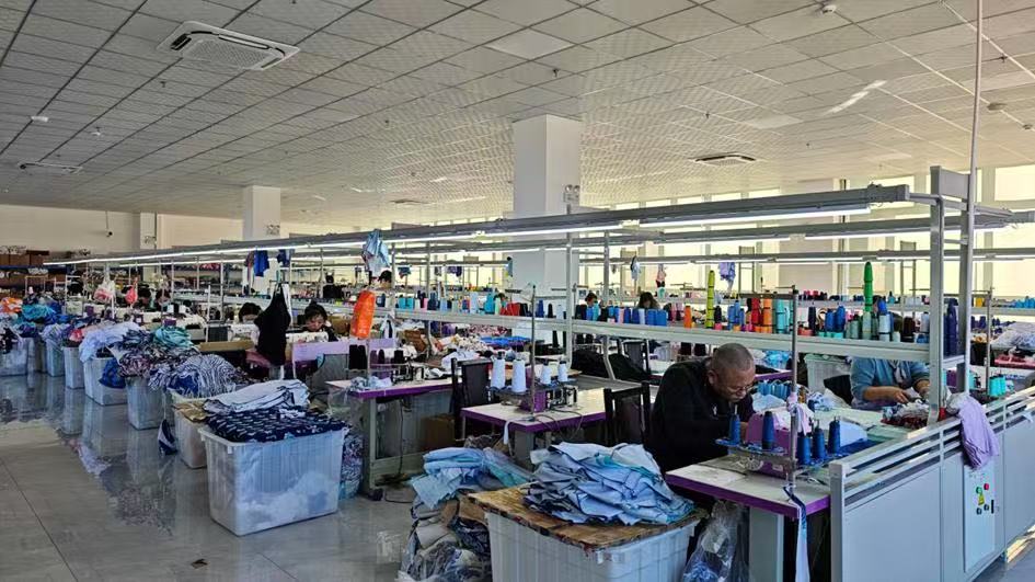 新建厂房内，工人正在赶制泳装。