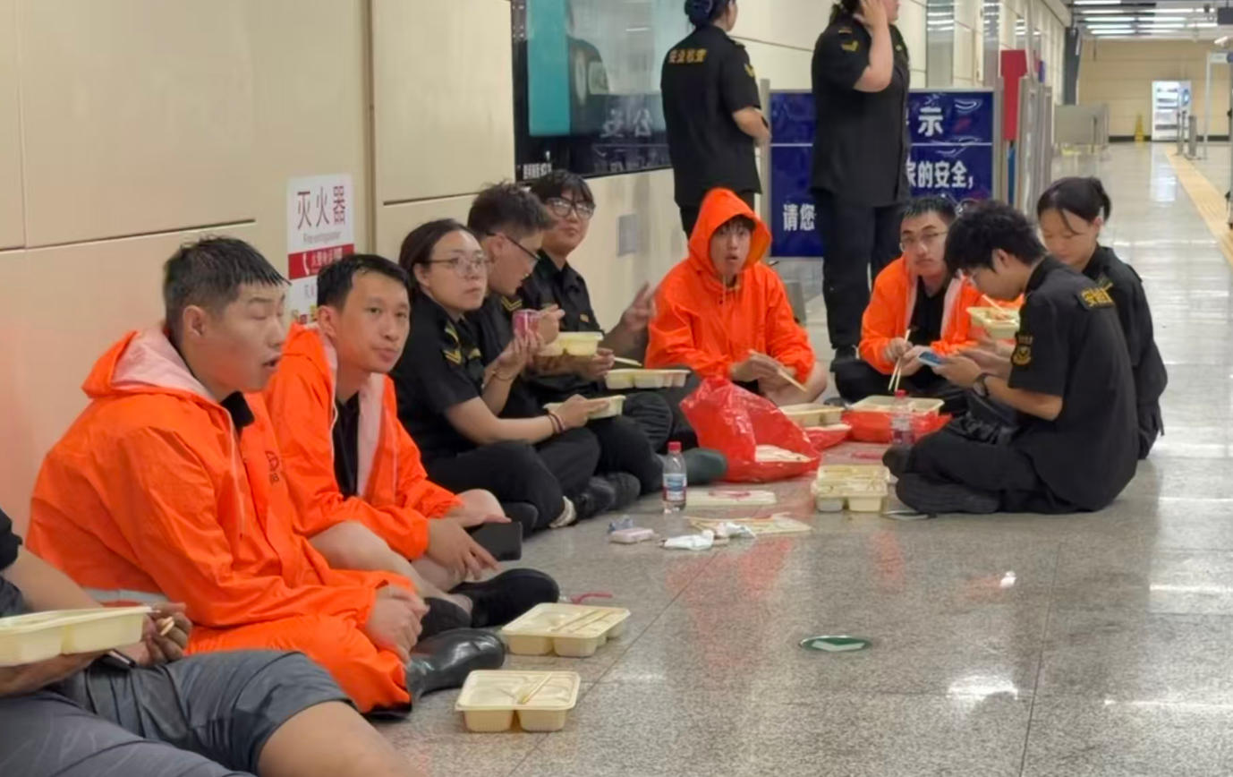 工作人员奋战后坐在地上休息、吃饭。沈阳地铁供图