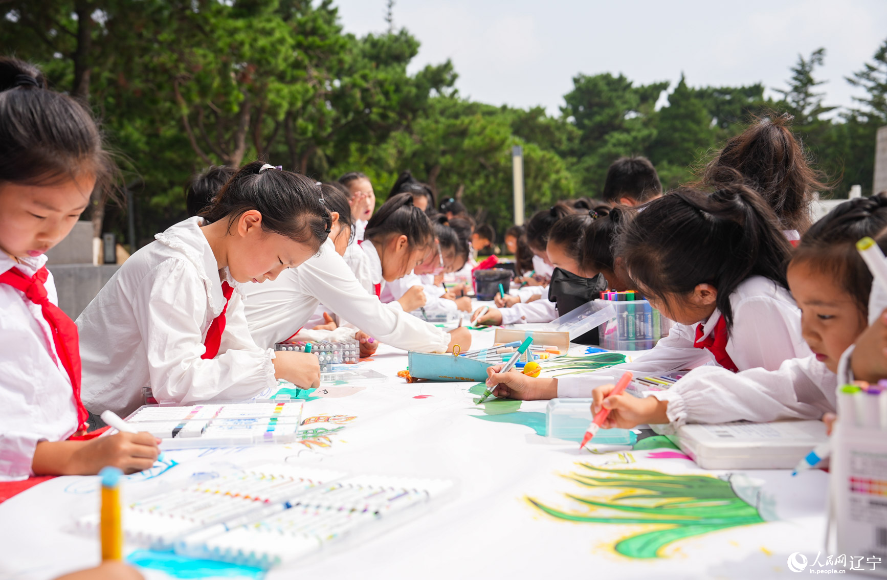 活动现场，少先队员为五位抗美援朝烈士肖像填色赋彩。人民网记者 邱宇哲摄