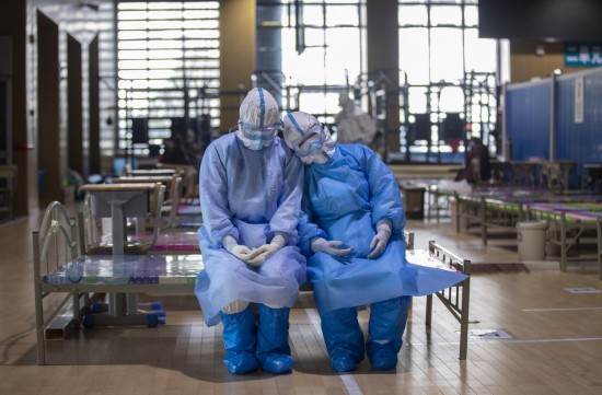3月10日，兩名青海醫療隊隊員在武昌方艙醫院等待出艙時小憩。新華社記者 費茂華 攝